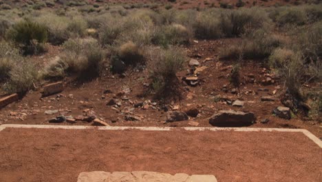 Eine-Sich-Bewegende,-Nach-Unten-Geneigte-Aufnahme,-Die-Von-Einer-Wüstenlandschaft-Zu-Einer-Steinstruktur-Namens-„blowhole“-Am-Wupatki-Nationalmonument-In-Arizona-übergeht
