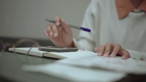 las manos de la mujer usan calculadora hace cálculos y análisis de los gastos ingresos