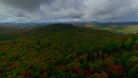 Drone-glides-over-colorful-mountains-as-clouds-casts-massive-shadows