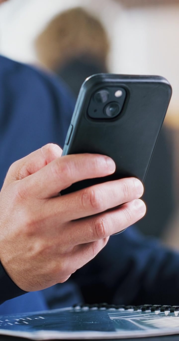 Primo piano di una persona che utilizza uno smartphone in ufficio