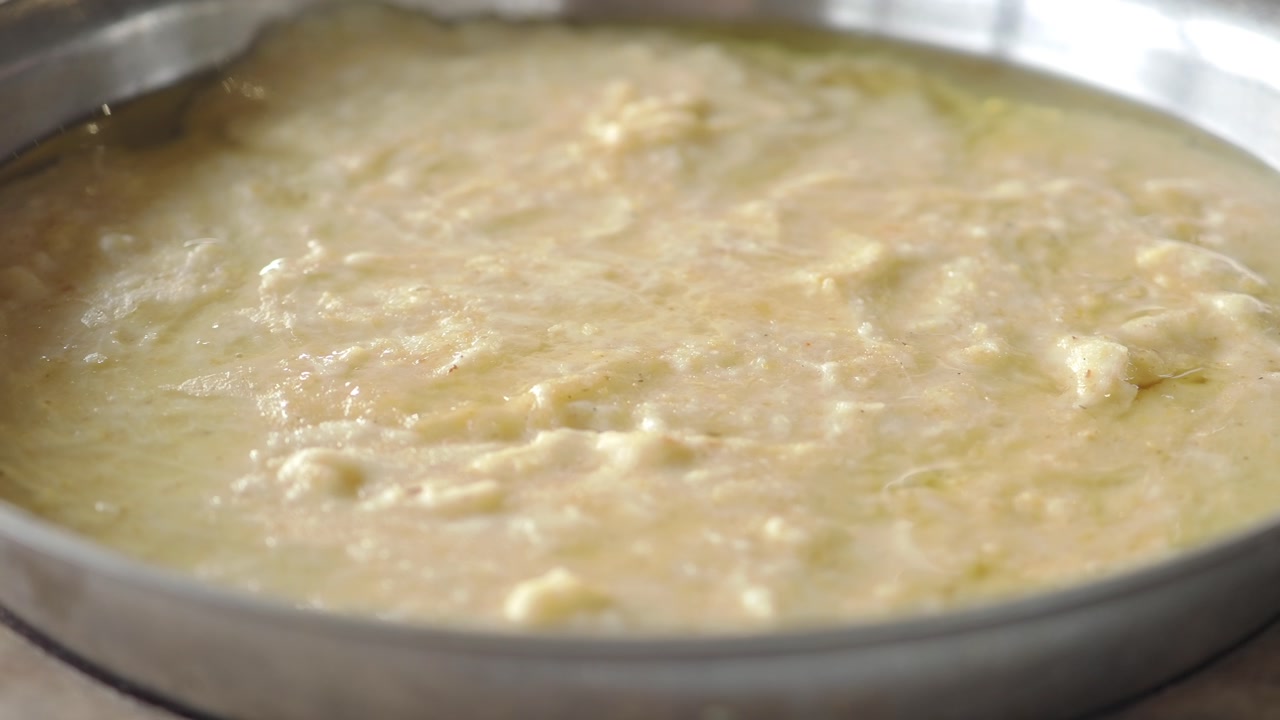 Close-Up of Creamy Food Simmering in a Metal Pan