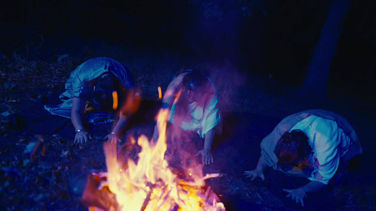 Women in Ritualistic Ceremony by a Campfire at Night