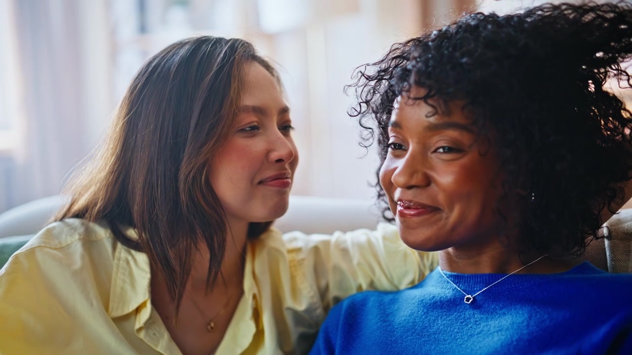 Female couple comforting home. Girlfriend kissing forehead, tender care support.