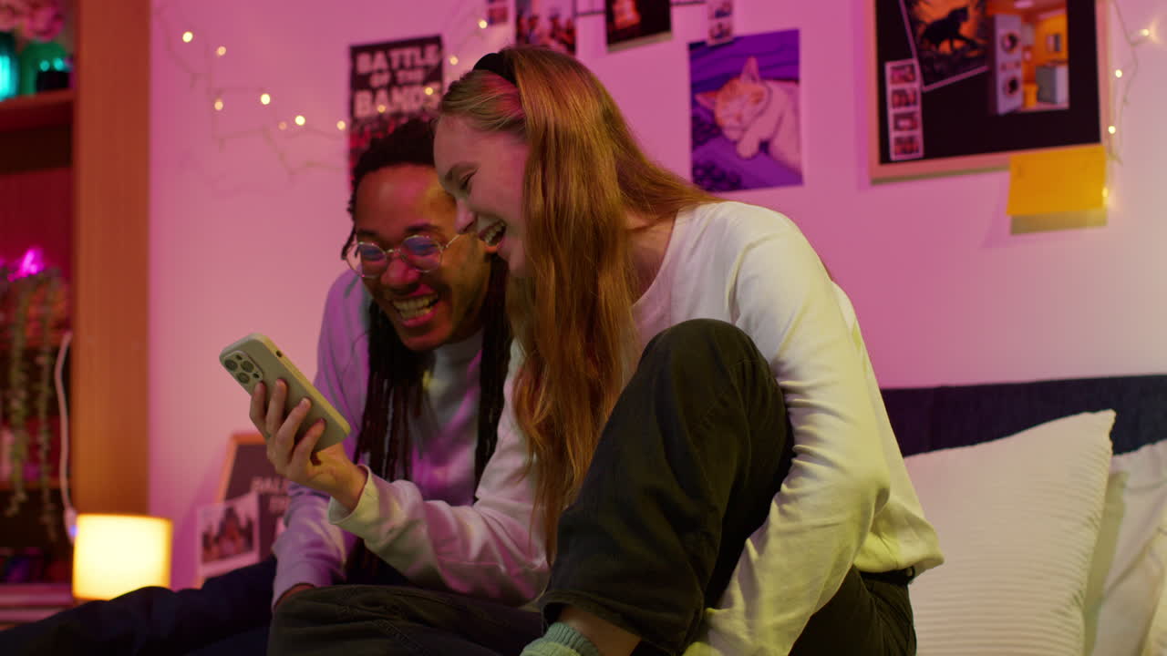 dos amigos riendo y mirando un teléfono juntos