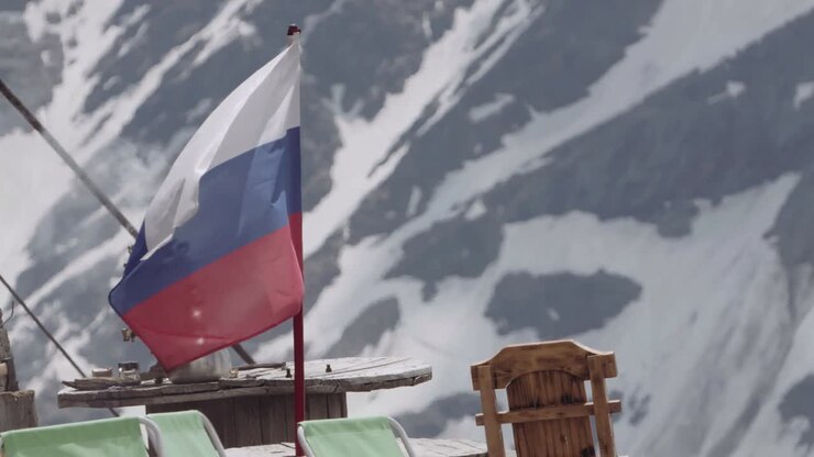 Drapeau russe flottant sur un camping de montagne enneigé