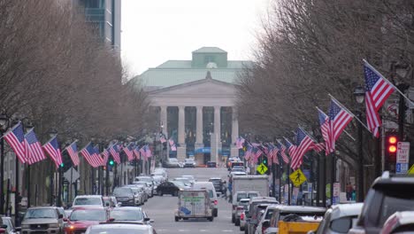 usa city street with cars and flags surrounded by buildings trees and noisy crowd under clear sky