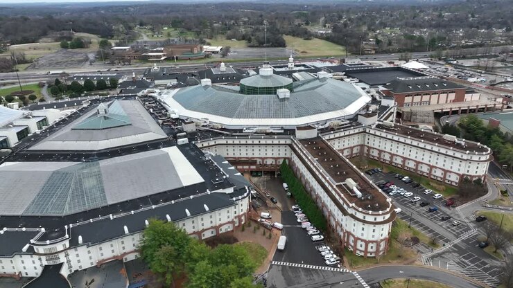 Complesso Opryland Hotel and Convention Center a Nashville, con l'iconico design del tetto, gli edifici circostanti, le aree di parcheggio e il paesaggio suburbano. Vista aerea