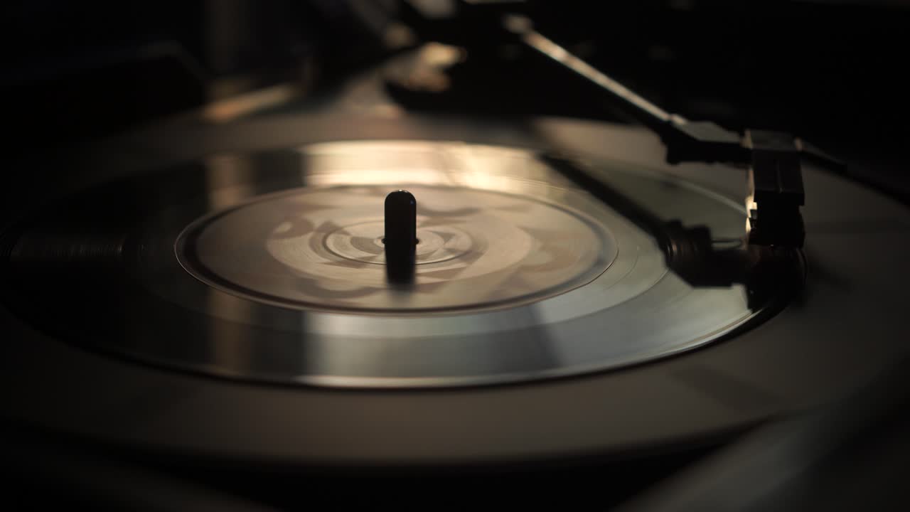 Starter afspilning af enkelt vinylplade, placerer nål på pladen, nærbillede.
