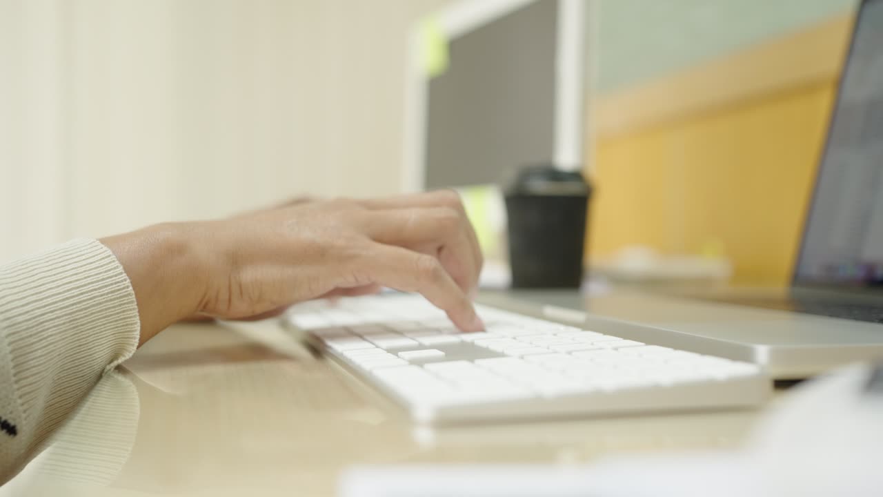 las manos de la mujer de negocios escribiendo en el teclado de la computadora portátil para buscar información, informe de investigación de marketing en el escritorio de la oficina