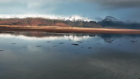 Reflejos-Nublados-En-El-Agua-Con-La-Montaña-De-La-Capa-De-Hielo-En-El-Fondo