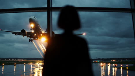 watching airplane landing in bad weather from airport window
