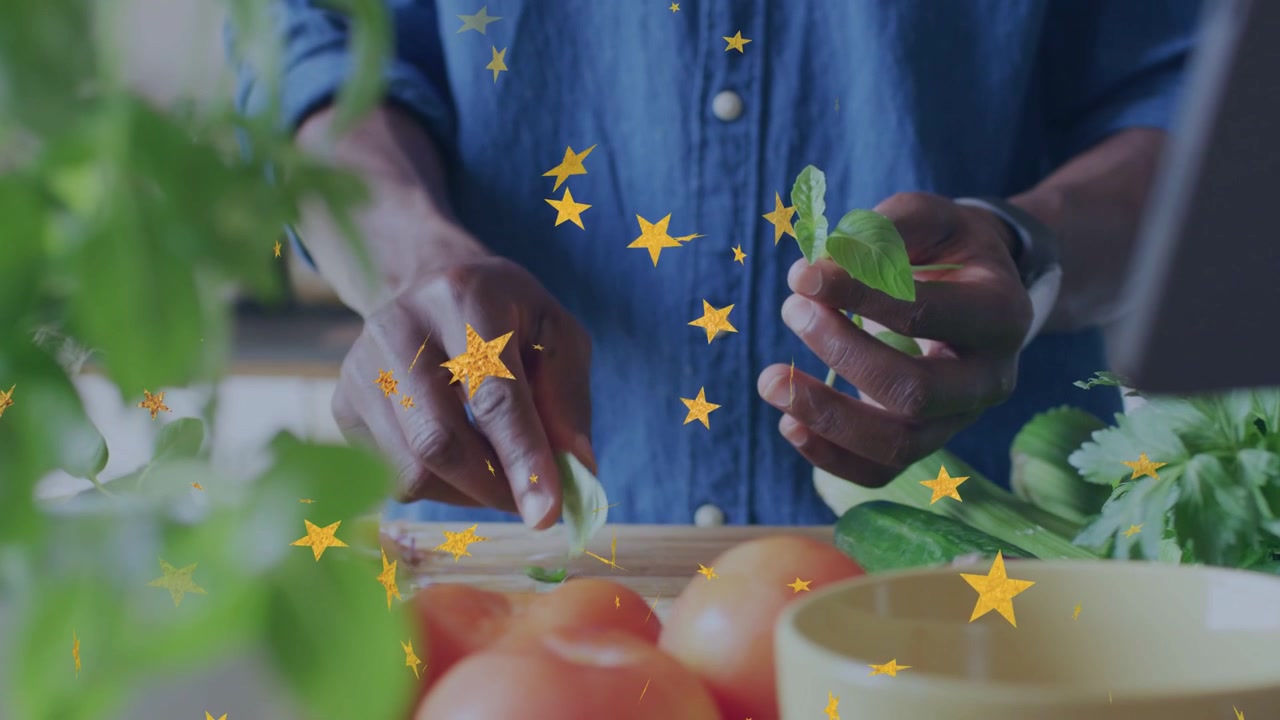Homme tenant un brin d'herbe aromatique, cueillant des feuilles sur une planche, des tomates à cuisiner, des étoiles dérivant à travers le cadre