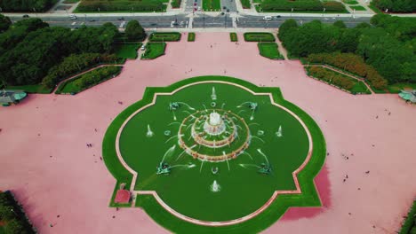 approaching shot from buckingham flower gardens fountain to the avenue with some traffic in the background, chicago