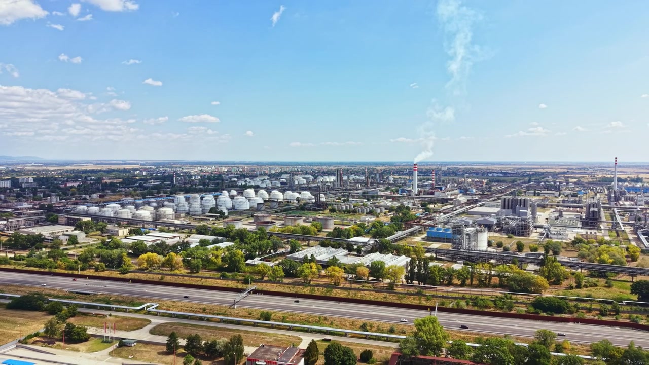 Zona industriale con serbatoi di stoccaggio e fabbriche sotto un cielo sereno di giorno