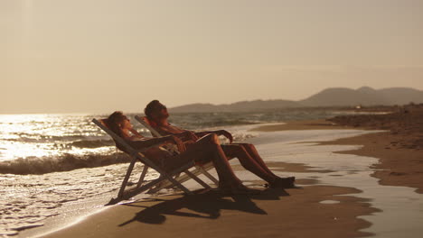 pareja relajándose en una puesta de sol en la playa