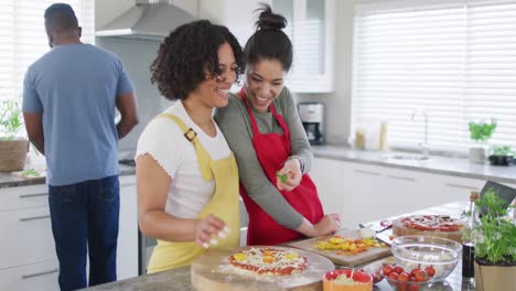 Happy-diverse-male-and-female-friends-making-pizza,-cooking-in-kitchen,-in-slow-motion