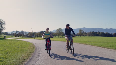 young smiling couple enjoying a bike ride in the autumn countryside, front view