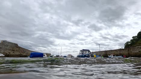 waves splashing near boats in dysart harbor