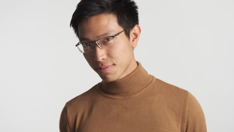 hombre asiático con gafas mirando a la cámara.
