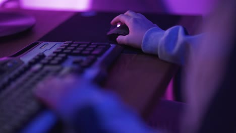 primer plano de las manos que muestra a un jugador presionando los botones del teclado mientras juega un videojuego en línea