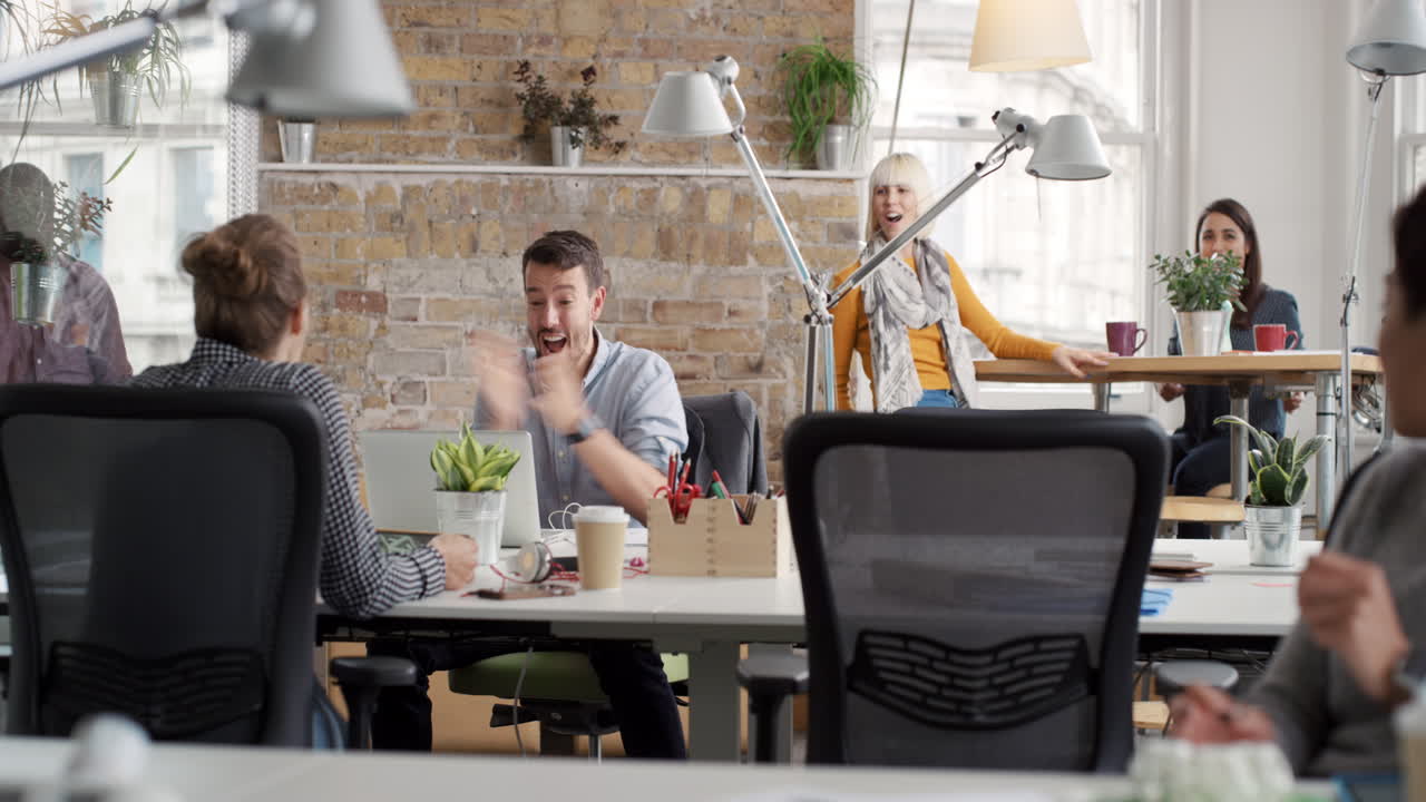 Businessman with arms raised celebrating success watching sport victory on laptop diverse people group clapping expressing excitement in office