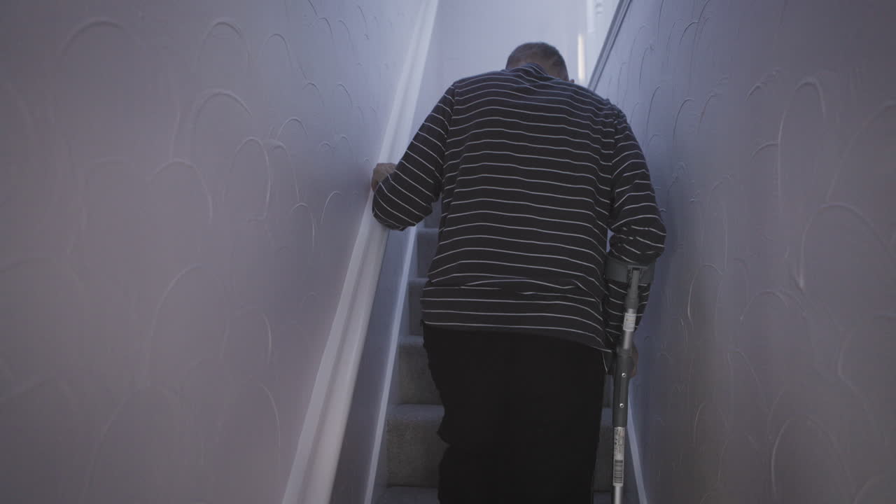Man using crutches on stairs