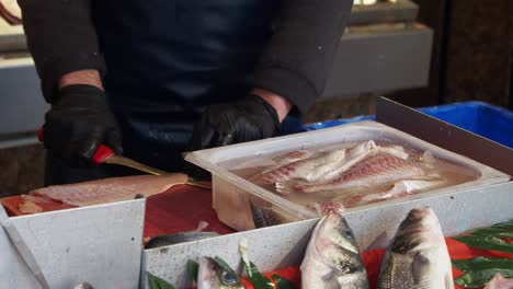 fishmonger preparing fresh sea bass at a fish market