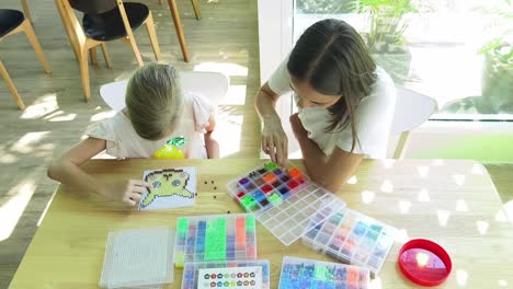 mother and daughter doing a beading craft