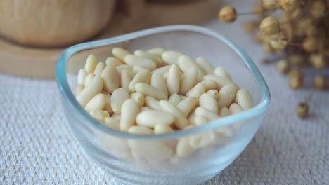 a close-up view of a glass bowl filled with pine nuts