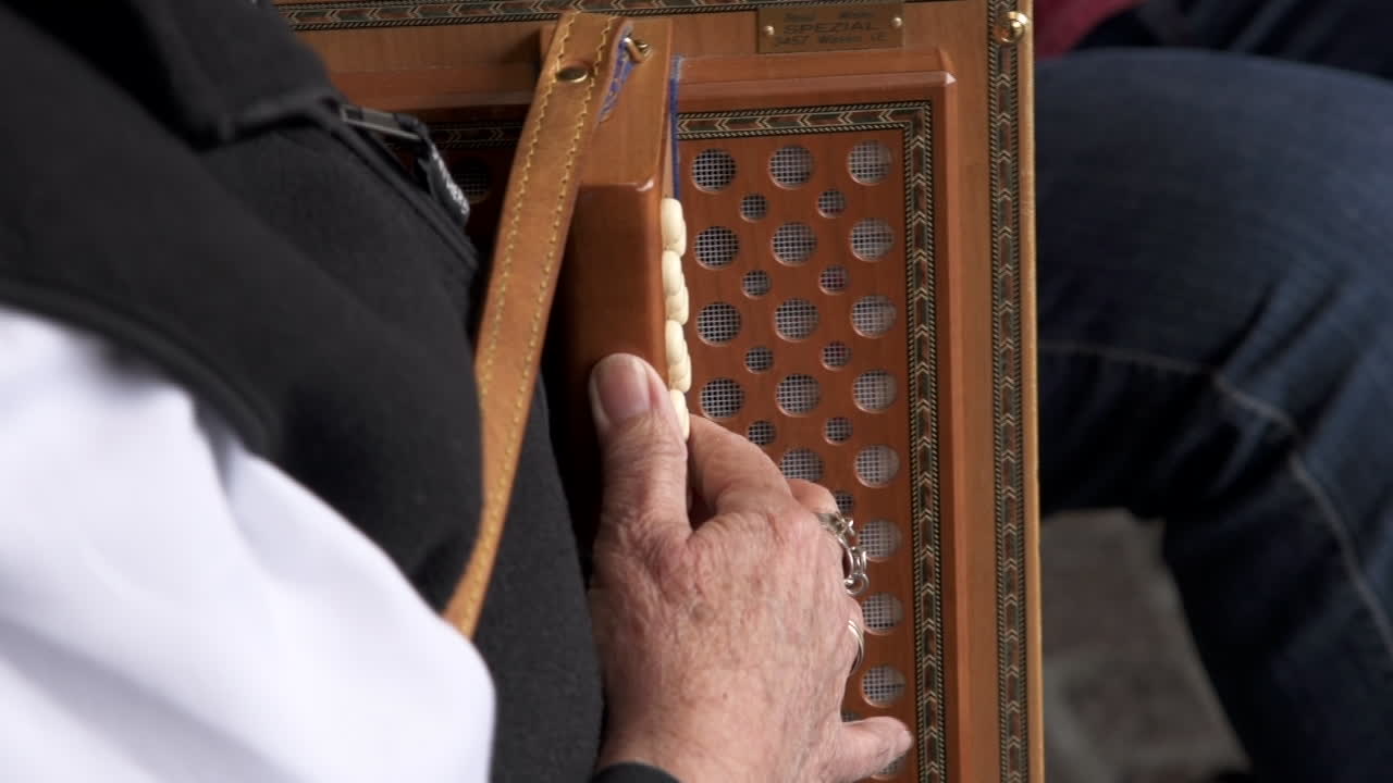 Primo piano di anziano che suona la fisarmonica