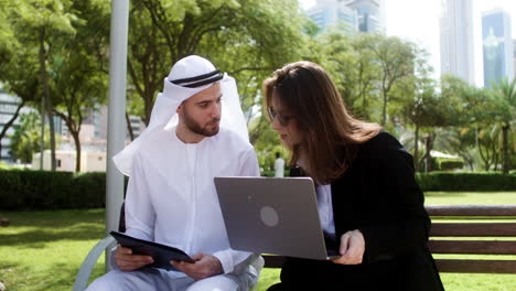 Man-and-woman-sitting-on-the-bench-of-a-park