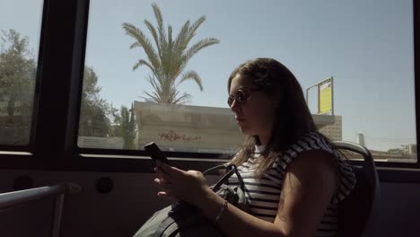 woman using phone on a bus