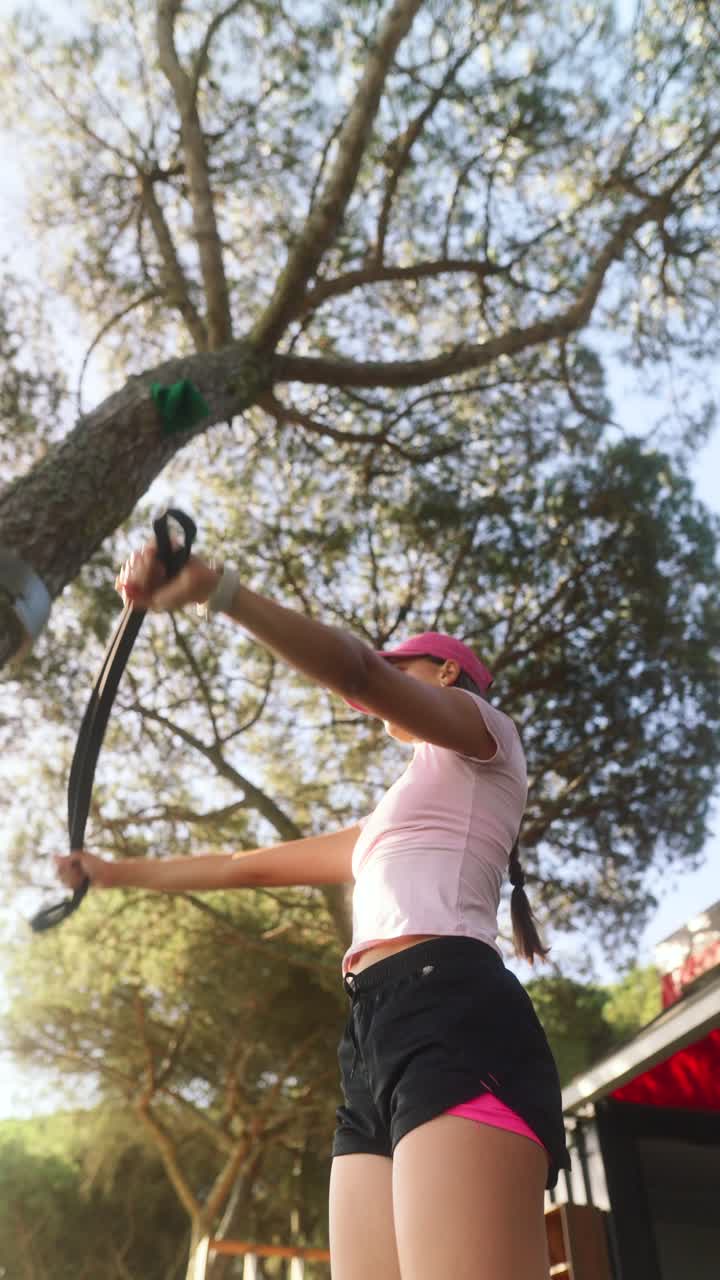 mujer haciendo ejercicio al aire libre con banda de resistencia