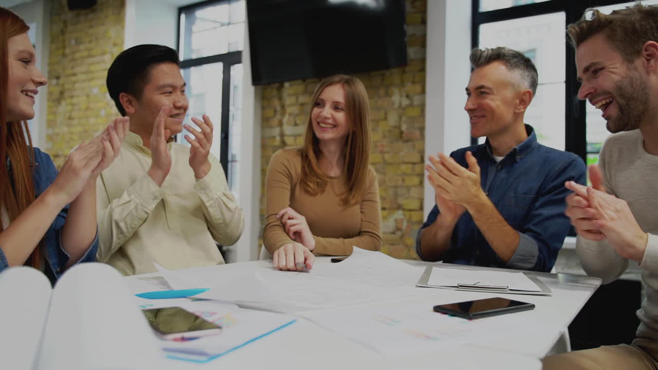 el equipo de trabajo multiétnico aplaude una buena idea. reunión de jóvenes hombres y mujeres de negocios.