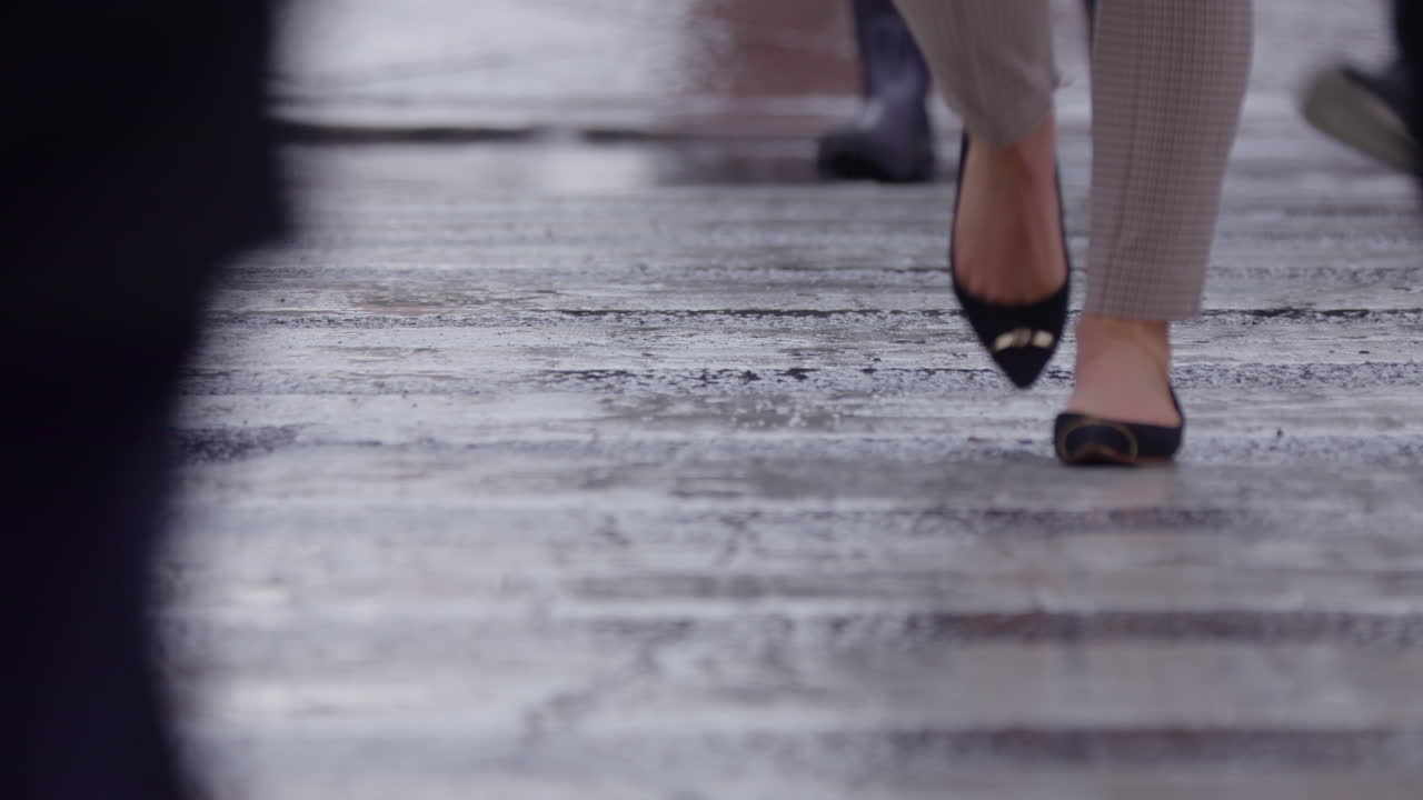 Slow Motion. People's feet, walking across a crosswalk on a wet day. New York City traffic. Rain, Manhattan NYC