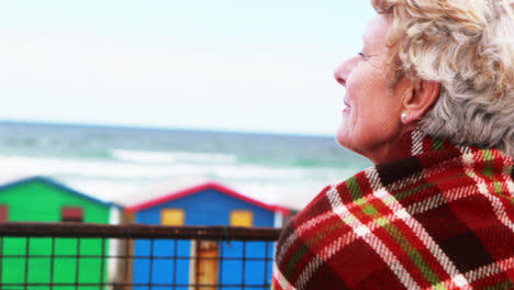 una mujer mayor disfrutando de la vista en la playa.