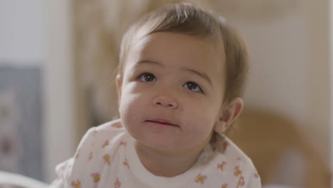 close up shot of an adorable baby girl spending time with mum and dad in bed on a lazy sunday morning