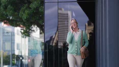 mujer de negocios caminando y hablando por teléfono