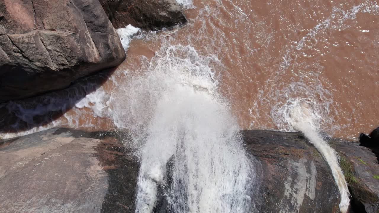 toma cerrada de una cascada que fluye desde las colinas y se encuentra con el arroyo