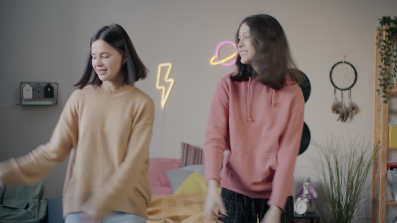 Two sisters dancing in their bedroom