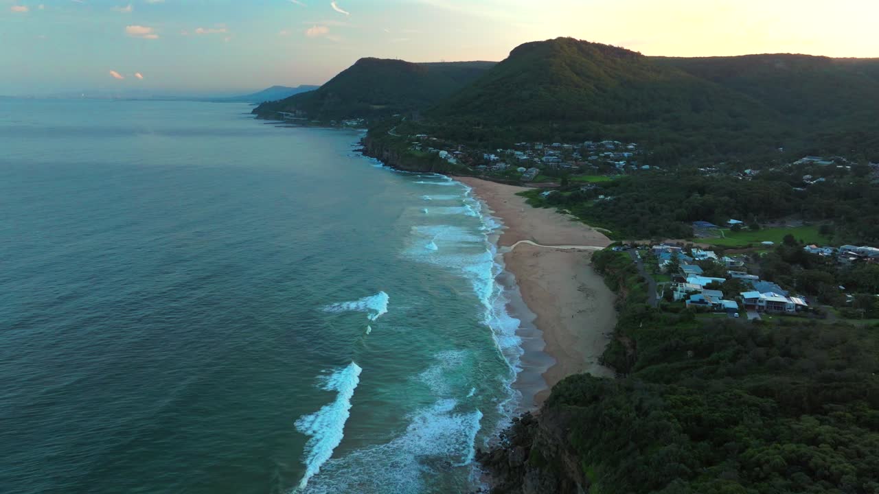 stanwell park playa cimas arroyo drone aéreo nsw australia amanecer azul hora de oro wollongong sydney colina calva costa sur illawarra coal cliff throull vecindario surfing olas hacia adelante pan up