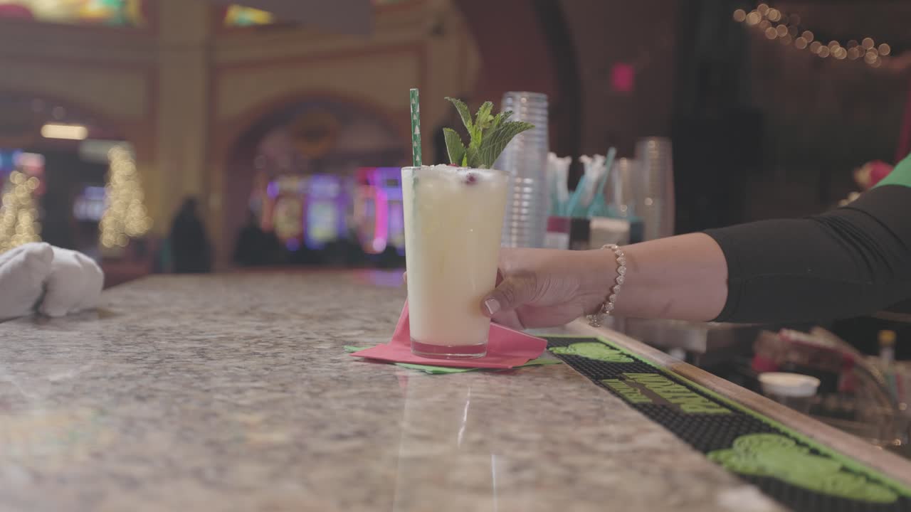 A bartender slides a drink to Santa Claus in festive setting. Ideal for holiday celebrations, Christmas parties, bartending, drinks service, and seasonal event themes