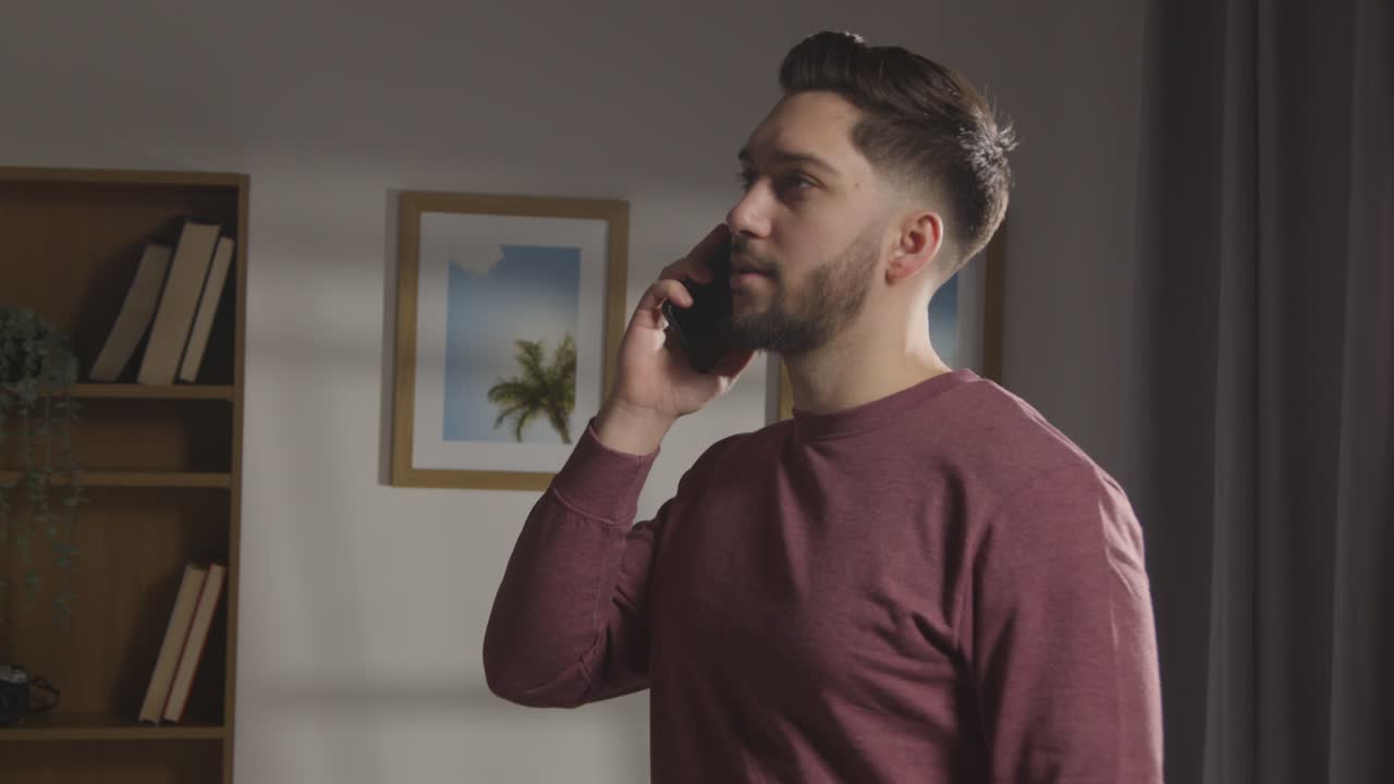 joven complacido en casa recibiendo una llamada telefónica que confirma la oferta de trabajo 2