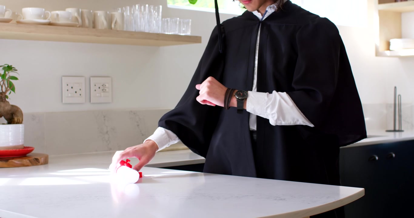 Uomo in vestaglia al bancone della cucina che controlla l'orologio al polso, prende una pergamena e si avvia per una cerimonia.