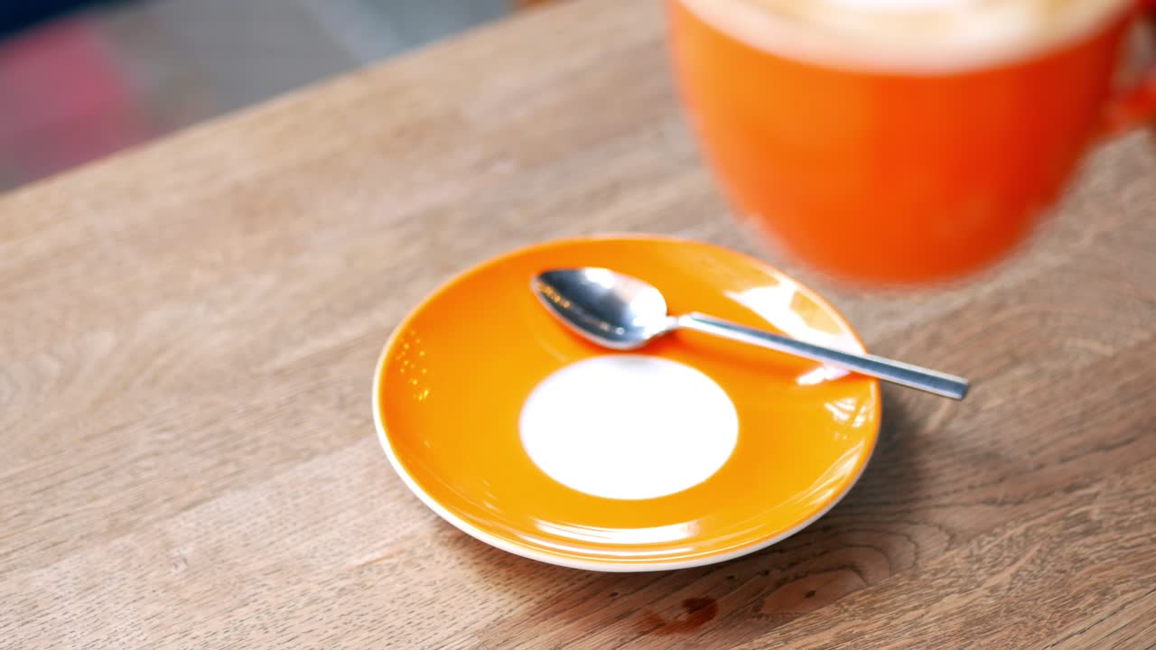 tazas de café naranja en una mesa de madera