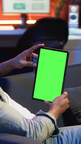 vertical video black remote worker looking at green screen on his device at home