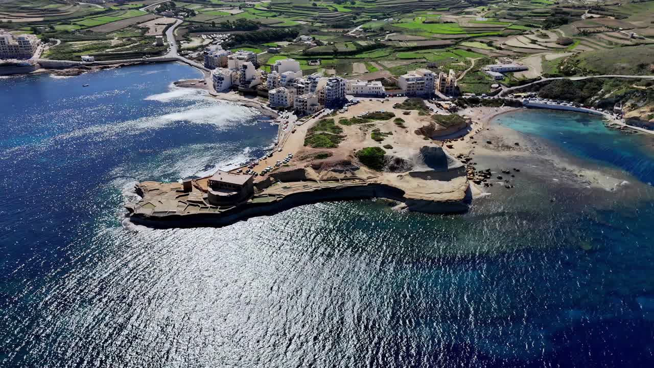 Luchtfoto met hoog perspectief van de historische Qolla l-Bajda Batterij en de Xwejni Zoutpannen op Gozo, Malta, tijdens een heldere zonnige zomerdag, met oude kustversterkingen en traditionele zoutwinning