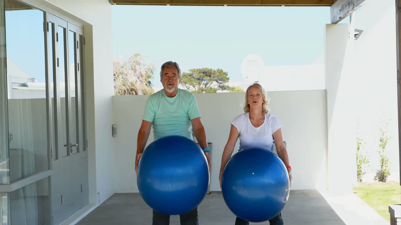 Senior couple exercising with exercise ball