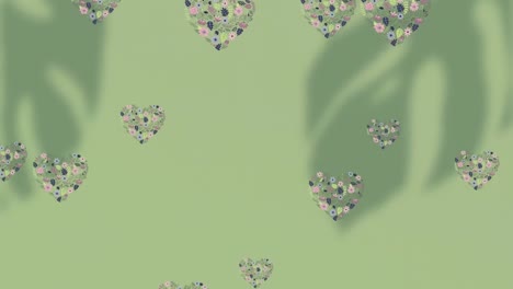 Animation-Eines-Blumenmusters-Mit-Fallenden-Herzen-Auf-Grünem-Hintergrund