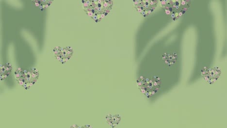 animación de un patrón floral con corazones cayendo sobre un fondo verde